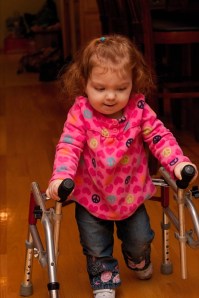Bridget using her loaner before qualifying for her own walker.